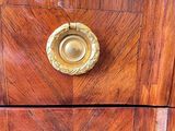 a wooden chest of drawers with brass knobs on it