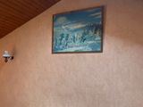 a picture of a bedroom with a bed and a painting on the wall