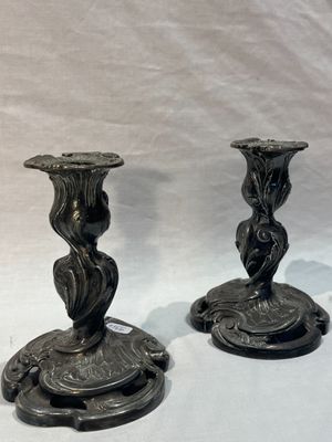 two black candles that are sitting on a white table