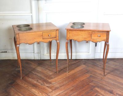 two small tables with bowls on them on the floor