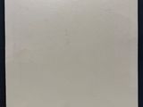 une feuille de papier vierge accrochée à un mur noir