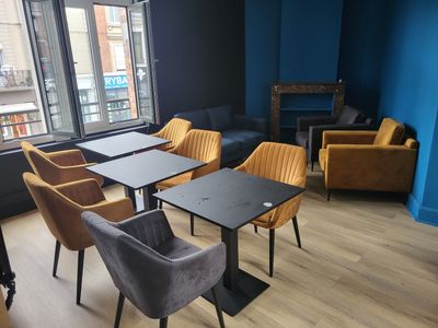 de nombreuses chaises et tables dans une pièce dotée d'une grande fenêtre