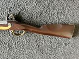 an old gun with a brass handle on a gray carpet