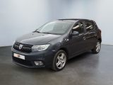 La voiture grise est garée dans une pièce au sol noir.