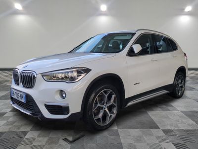 un SUV BMW blanc garé dans un garage au sol carrelé