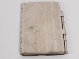 an antique silver cigarette case on a white surface