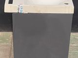 a trash can sitting on the ground next to a black wall