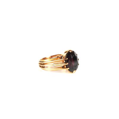 a close up of a ring with a black stone on it