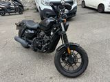 a black motorcycle parked in a parking lot next to a white van