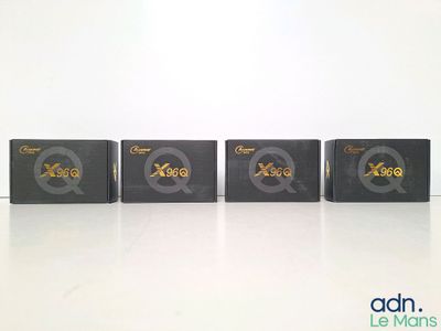four black boxes with gold letters are lined up on a white surface