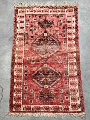a red rug with a diamond design on it