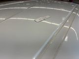 a close up of a white car with a tag on it ' s hood