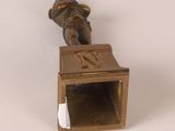 a bronze statue of a person holding a box