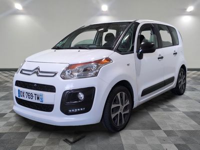 La petite camionnette blanche est garée dans une grande pièce.