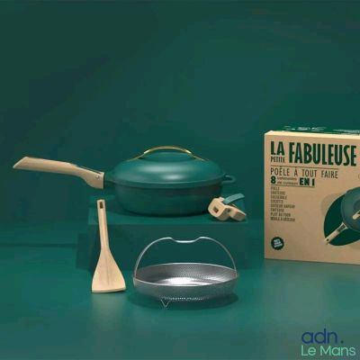 une casserole verte et une cuillère en bois à côté d'une boîte