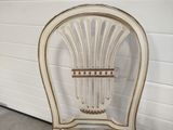 a white chair with a basket on the back of it