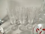a lot of wine glasses and a bottle on the table