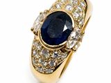 a close up of a ring with a sapphire and diamonds on it