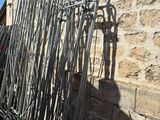 a large pile of metal pipes leaning against a brick wall