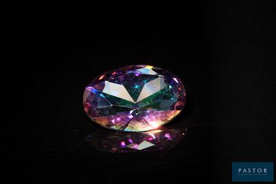 un gros plan d'un diamant coloré sur une surface noire
