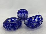 three blue glass beads sitting on top of a white surface