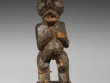 une image d'une statue en bois représentant un homme tenant un bébé