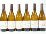 six bouteilles de vin sont alignées sur une surface blanche