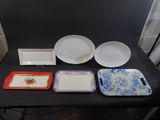 several plates and trays are sitting on a table in front of a black backdrop