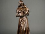 a bronze statue of a woman holding a child
