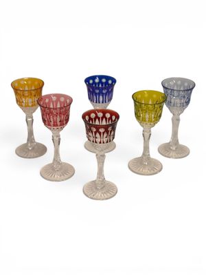 four different colored glass goblets sitting on top of each other