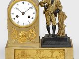 une horloge en or surmontée d'une statue représentant un homme tenant un chien dans ses bras