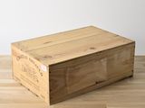 une boîte en bois vide posée sur un parquet en bois dur