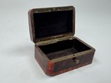 a small wooden box with a black lid on a white surface