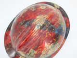 a picture of a red and black marble on a white surface