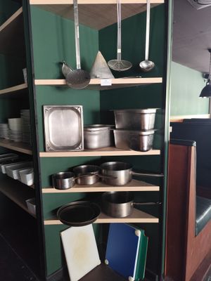 de nombreuses casseroles et poêles sur les étagères de la cuisine