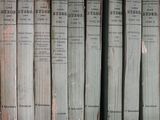 several old books are lined up in a row on a shelf