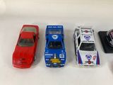 several toy cars are lined up in a row on a white surface