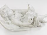 a statue of an angel laying down on a pillow