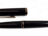 deux stylos à plume noirs et dorés posés l'un à côté de l'autre