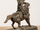 statue of a man riding a horse on a wooden table