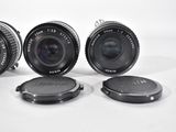 three camera lenses sitting next to each other on a white surface