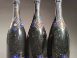 trois bouteilles de champagne posées côte à côte sur une table