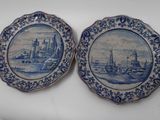 three blue and white plates with a picture of a city on them
