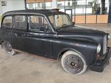 an old black car that is parked in a garage