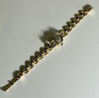 gold tone bracelet with clear crystal stones on a white surface