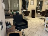 a picture of a salon with a lot of chairs in it