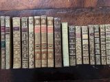 several old books are lined up in a row on a table