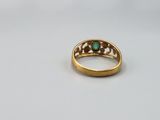 a close up of a gold ring with a green stone