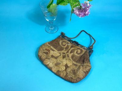 a small purse sitting on a table next to a vase of flowers