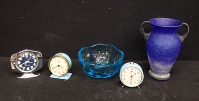 un vase en verre bleu, un bol en verre bleu, une montre en verre bleu et un vase en verre bleu